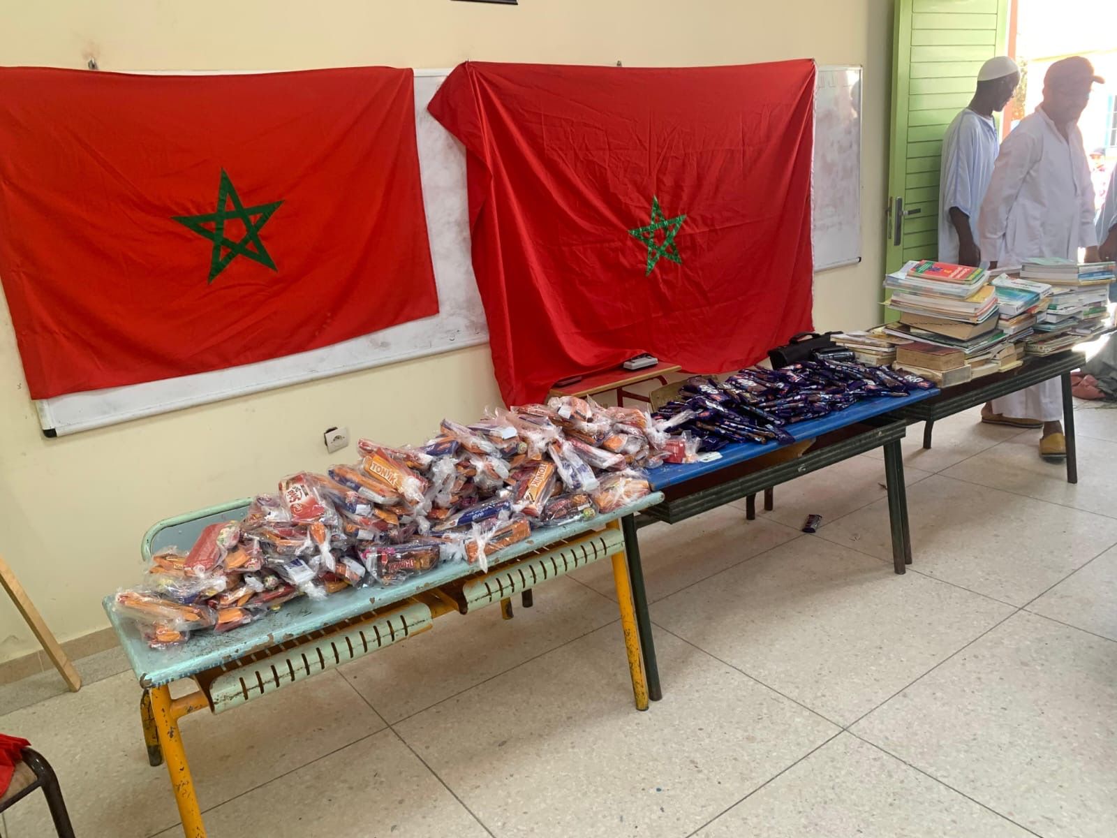 Goûters préparés sur des tables devant des drapeaux marocains